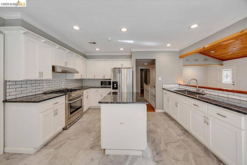 5827 Lookout Ct, CA 95233 Kitchen featuring white shaker-style cabinetry, stone countertops, stainless steel appliances, subway tile backsplash, and recessed lighting