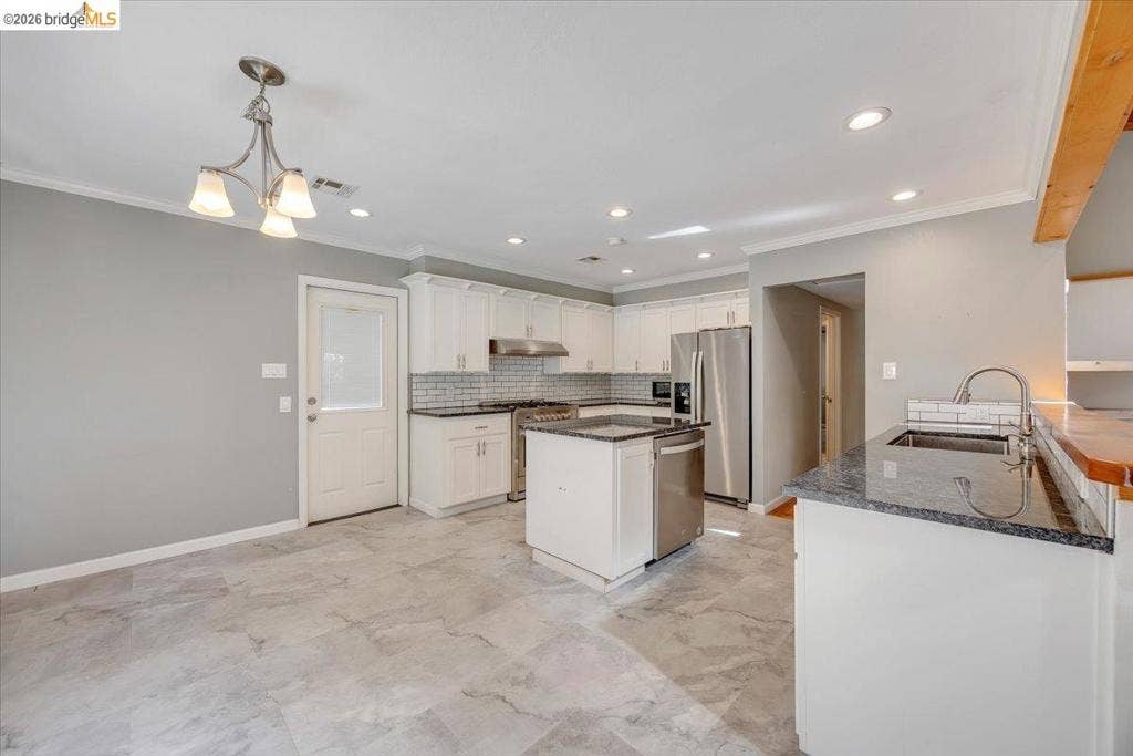 5827 Lookout Ct, CA 95233 Kitchen featuring white cabinetry, stone countertops, stainless steel appliances, a center island, and tile flooring