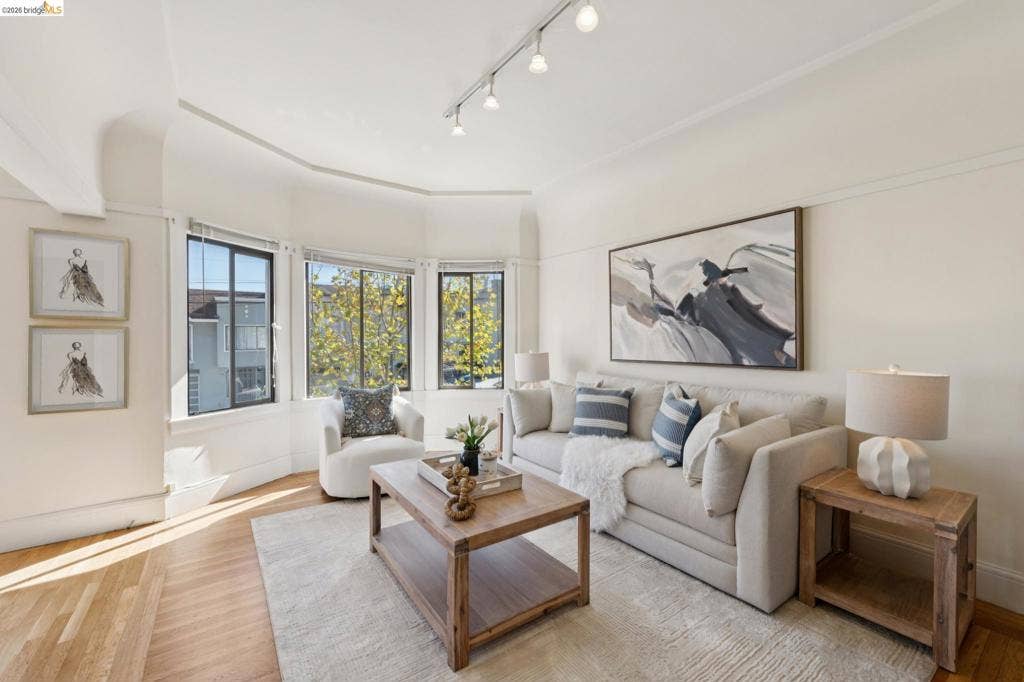 715 17Th Ave, San Francisco, CA 94121 Bay window featuring three paneled glass windows, wood-finish flooring, and adjustable ceiling-mounted track lighting