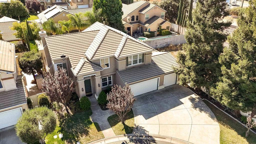 4600 Via Terreno, Modesto, CA 95357 Two-story residence featuring a concrete tile roof, stucco exterior, three-car garage, and a spacious concrete driveway