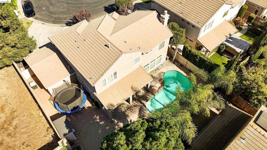 4600 Via Terreno, Modesto, CA 95357 Two-story residence featuring a tile roof, an in-ground swimming pool, a covered patio, and mature landscaping
