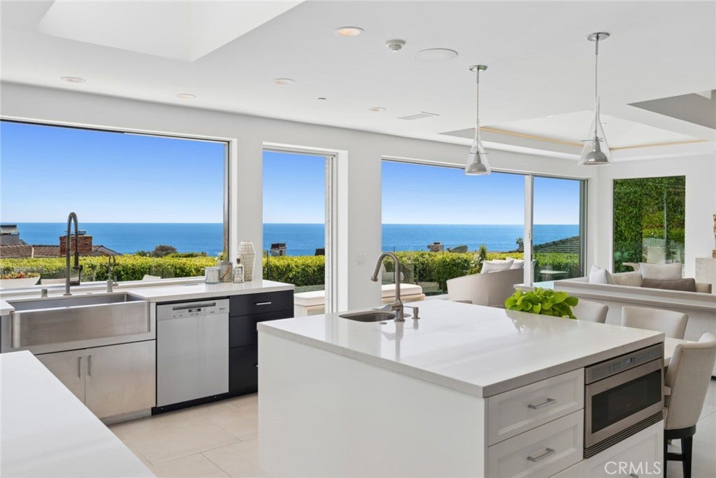 A suite of premium Wolf, Miele and Sub-Zero appliances, including a six-burner cooktop, dual ovens and dual dishwashers, creates a refined culinary environment that reflects the same uncompromising standard found throughout the home.