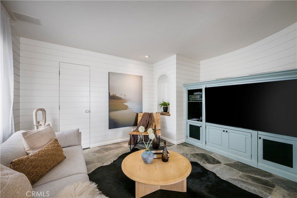 Sitting room adjacent to the living room with a powder bath beyond