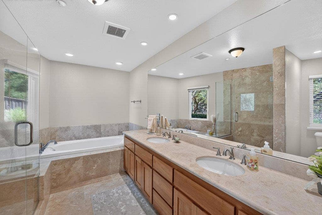 110 Mattison Court, Aptos, CA 95003 Primary bathroom with stone flooring, dual sinks, shower, and jetted tub.