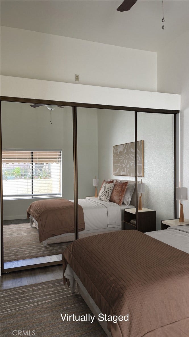 Virtually Staged Primary Bedroom - large closet space with closet organizers, vaulted ceiling and a ceiling fan.