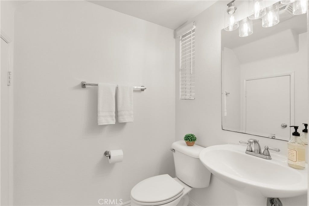 15 Poppyfield, Rancho Santa Margarita, CA 92688 The main level powder room is thoughtfully positioned for guests and features a pedestal sink, abundant natural light, and a clean, timeless design.
