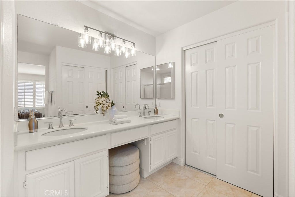 15 Poppyfield, Rancho Santa Margarita, CA 92688 The spacious primary bathroom features a dual sink vanity with expansive counter space, oversized mirrors, abundant storage, and a bright, functional layout designed for everyday convenience.