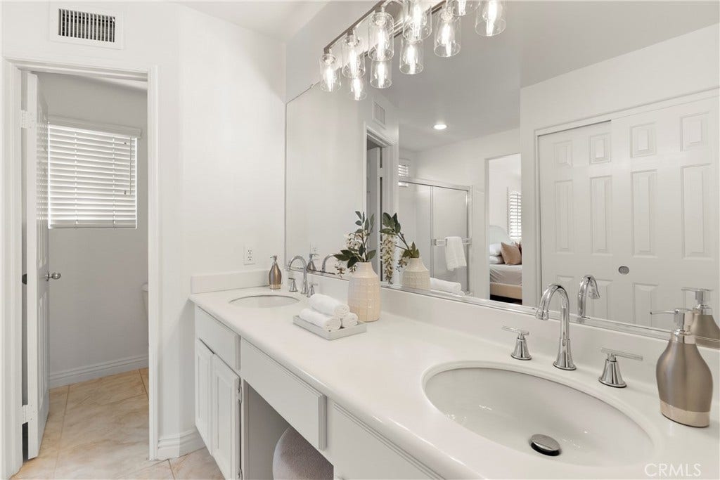 15 Poppyfield, Rancho Santa Margarita, CA 92688 A generous dual vanity provides plenty of space for morning routines, complemented by ample cabinetry, a dedicated seated vanity area, and classic finishes that create a bright and welcoming atmosphere.
