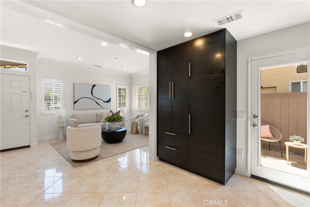 15 Poppyfield, Rancho Santa Margarita, CA 92688 Floor-to-ceiling custom built-in cabinetry offers exceptional storage while creating a seamless transition between the living room, kitchen, and private patio.