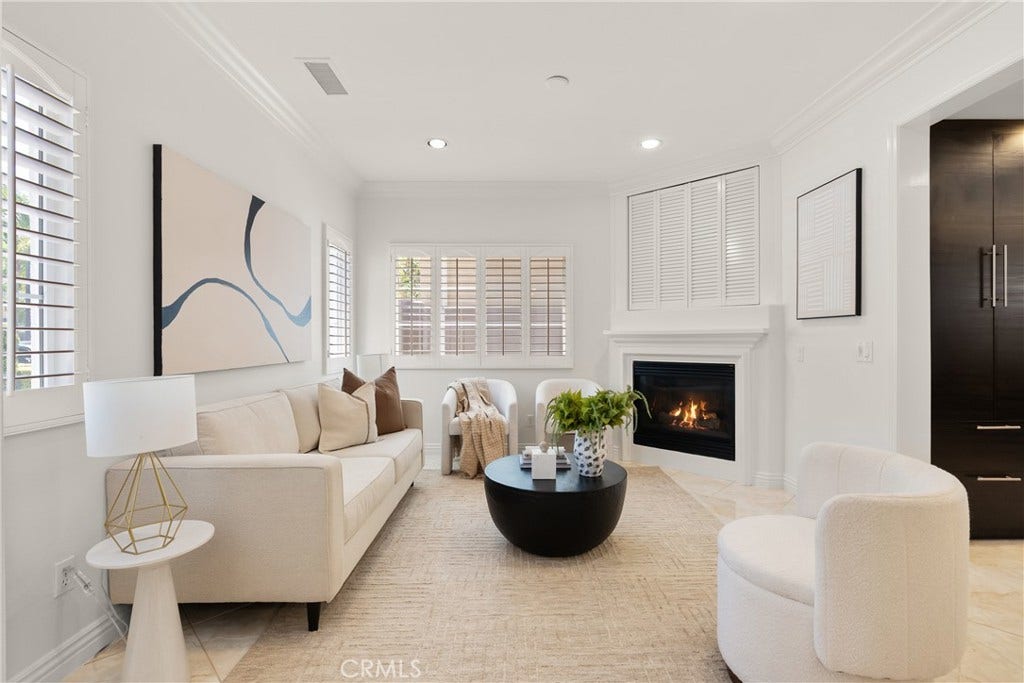 15 Poppyfield, Rancho Santa Margarita, CA 92688 Bright and inviting living room featuring abundant natural light, plantation shutters, a cozy fireplace, and an open flow into the kitchen.