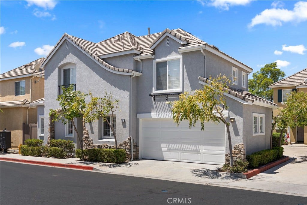 15 Poppyfield, Rancho Santa Margarita, CA 92688 Beautifully maintained front elevation featuring mature landscaping, a two-car attached garage, and attractive curb appeal.