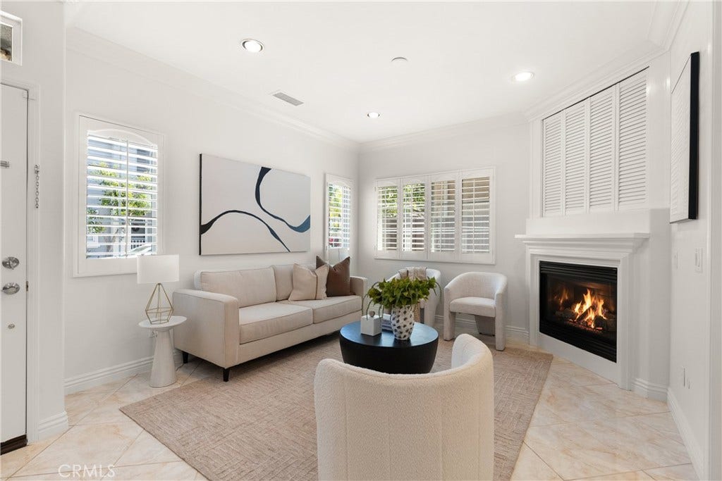 15 Poppyfield, Rancho Santa Margarita, CA 92688 Bright and inviting living room featuring plantation shutters, recessed lighting, crown molding, and a cozy fireplace that creates a warm gathering space.