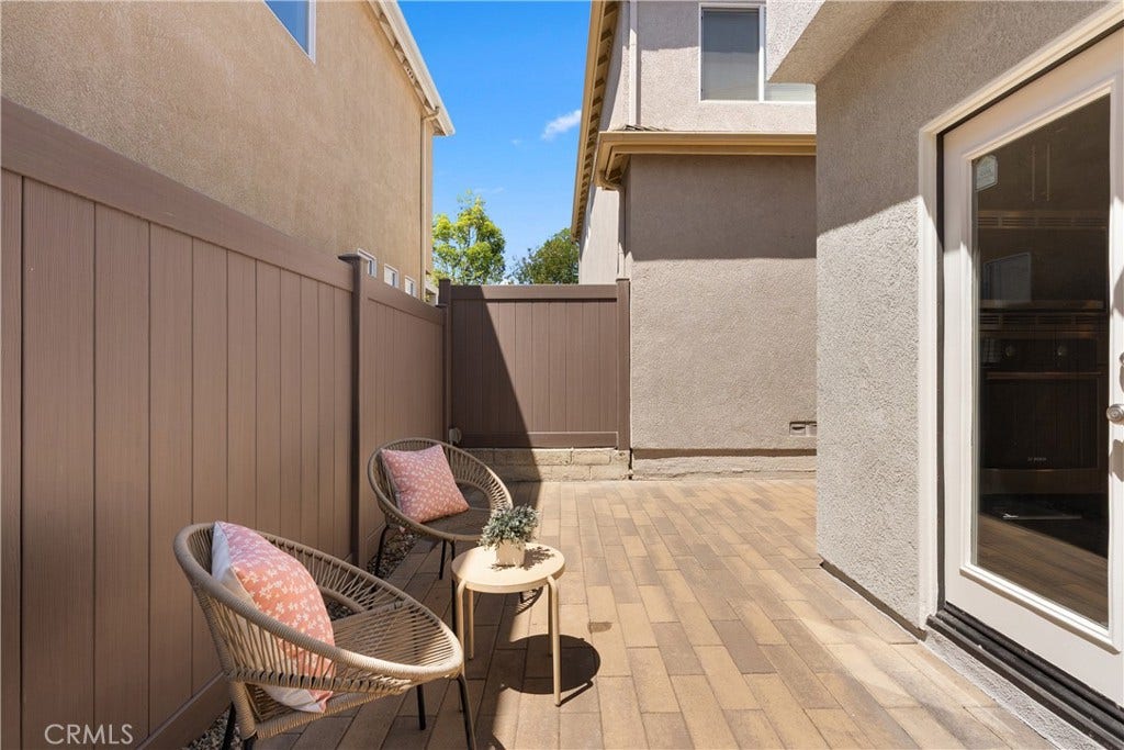 15 Poppyfield, Rancho Santa Margarita, CA 92688 The low maintenance patio offers an inviting outdoor retreat with durable paver hardscaping, space for lounging or dining, and direct access to the kitchen, creating an effortless extension of the home's living area.