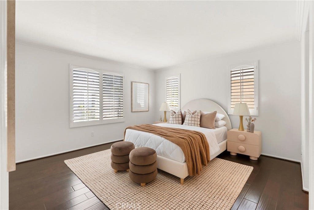 15 Poppyfield, Rancho Santa Margarita, CA 92688 The spacious primary suite offers a peaceful retreat with oversized windows, abundant natural light, rich wood flooring, and plenty of room for a sitting area or additional furnishings.