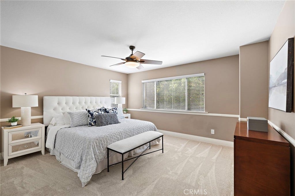 27 Las Cruces, Rancho Santa Margarita, CA 92688 Very spacious primary bedroom. The chair rail and fan add to the room. There are two closets for those that need a his and hers system.