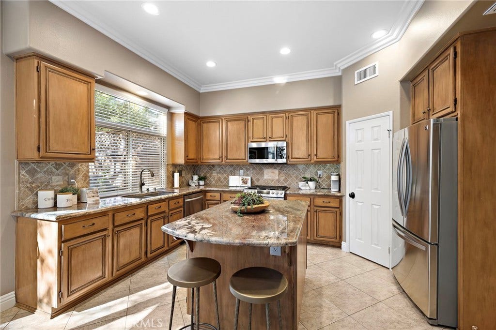 27 Las Cruces, Rancho Santa Margarita, CA 92688 Gorgeous kitchen with granite counters, an island with a breakfast bar for convenient seating. Stainless appliances and a walk-in pantry.The stainless fridge will remain with the home.
