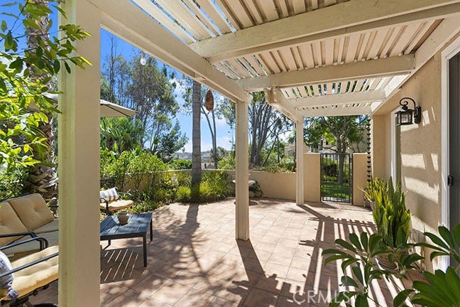 55 Fleurance, Laguna Niguel, CA 92677 Back yard with a Saltillo tile floor, patio cover for shade, and mature tropical landscaping