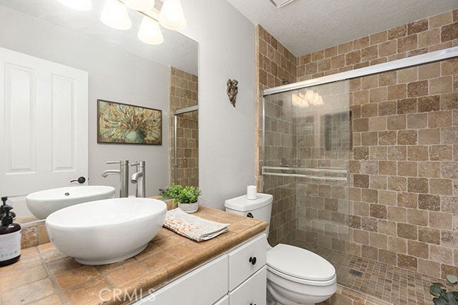55 Fleurance, Laguna Niguel, CA 92677 Main level full bathroom with a custom step in shower, upgraded lighting, and a vestibule sink