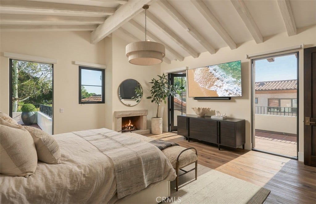 16 Pelican Point, Newport Coast, CA 92657 The redesigned primary retreat features hardwood flooring, a fireplace and direct access to a private balcony overlooking the surrounding coastal setting.