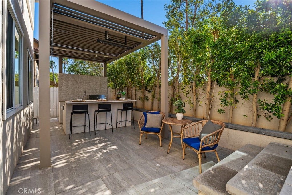 11 Calle Del Mar, Rancho Santa Margarita, CA 92688 Covered outdoor entertaining area features a StruXure pergola and built-in outdoor kitchen with bar seating.
