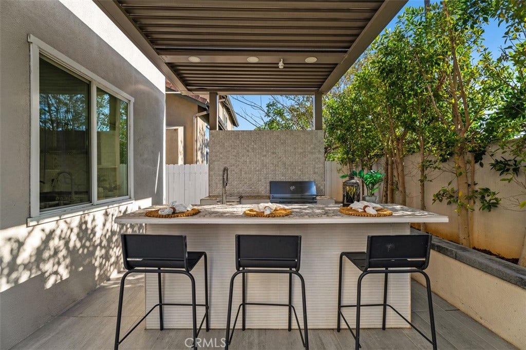 11 Calle Del Mar, Rancho Santa Margarita, CA 92688 Covered outdoor entertaining area features a StruXure pergola and built-in outdoor kitchen with bar seating.