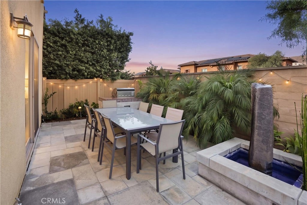 28242 Camino Del Rio, San Juan Capistrano, CA 92675 Private outdoor entertaining area featuring a built-in barbecue, custom fountain, lush landscaping, and generous space for al fresco dining.
