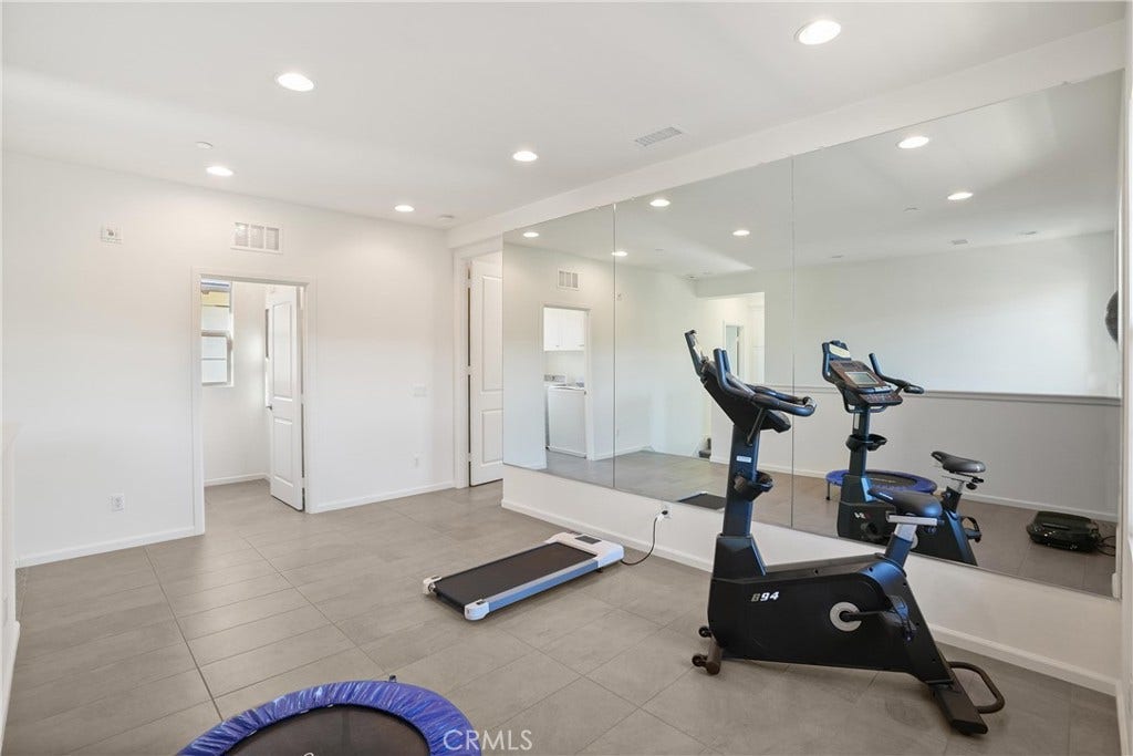 28242 Camino Del Rio, San Juan Capistrano, CA 92675 Upstairs loft with a full mirrored wall, recessed lighting, and ample space for a variety of uses.