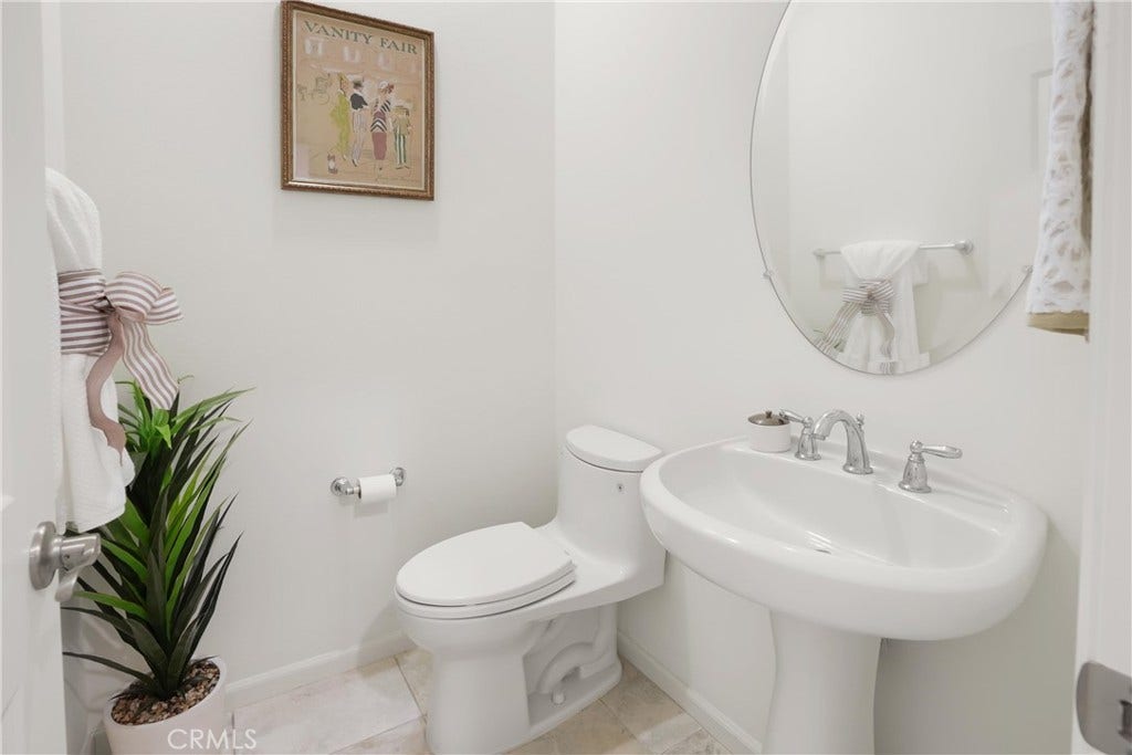 28242 Camino Del Rio, San Juan Capistrano, CA 92675 Convenient powder room featuring a pedestal sink, oval mirror, and neutral finishes.