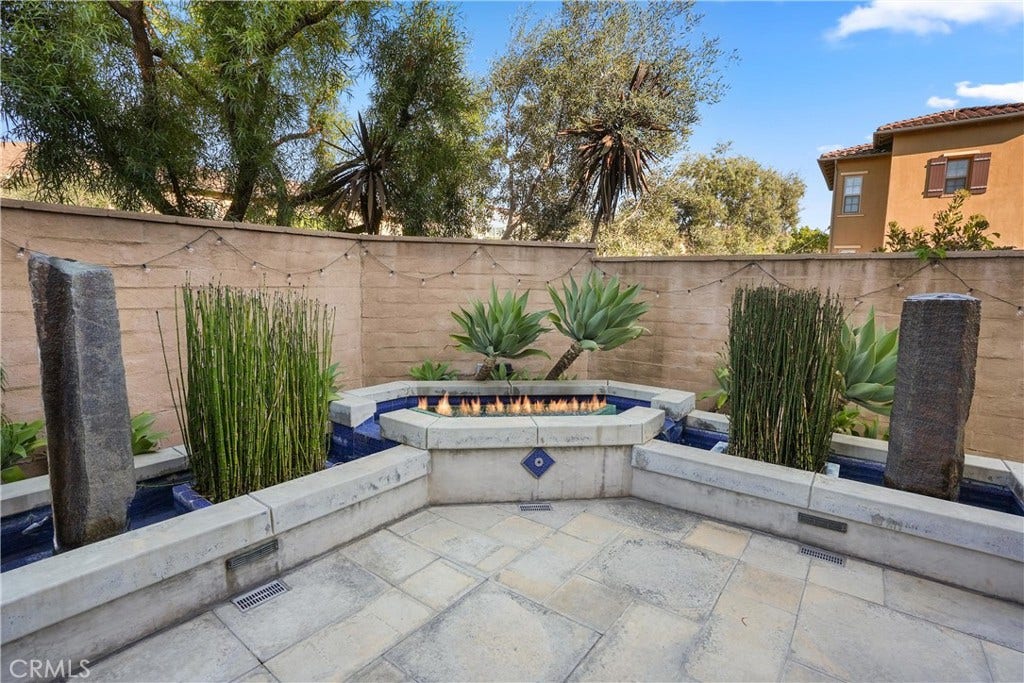 28242 Camino Del Rio, San Juan Capistrano, CA 92675 Landscaped backyard retreat featuring decorative water features, fire feature, and built in seating.