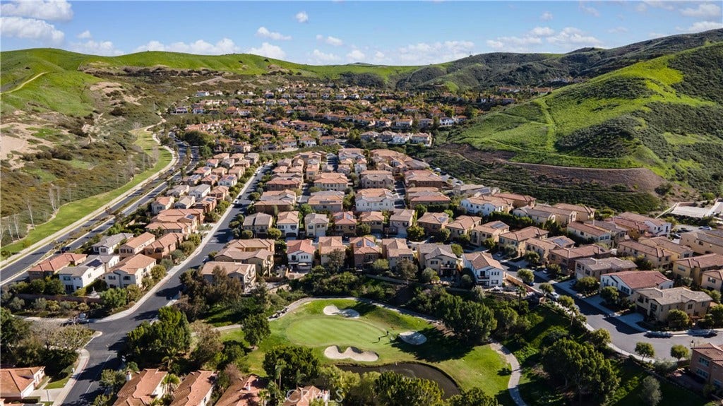 28242 Camino Del Rio, San Juan Capistrano, CA 92675 Aerial view showcasing the community surrounded by rolling hills with the golf course in the foreground.