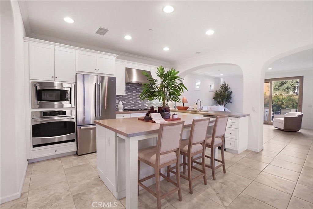 28242 Camino Del Rio, San Juan Capistrano, CA 92675 Another view of the kitchen highlighting the expansive center island, generous counter space, stainless steel appliances, and open-concept layout.