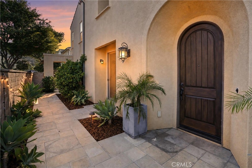 28242 Camino Del Rio, San Juan Capistrano, CA 92675 Inviting arched entry framed by mature landscaping and warm exterior lighting.