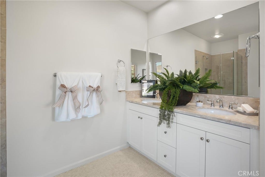 28242 Camino Del Rio, San Juan Capistrano, CA 92675 Primary bathroom with dual sinks, generous vanity storage, and an expansive wall mirror.