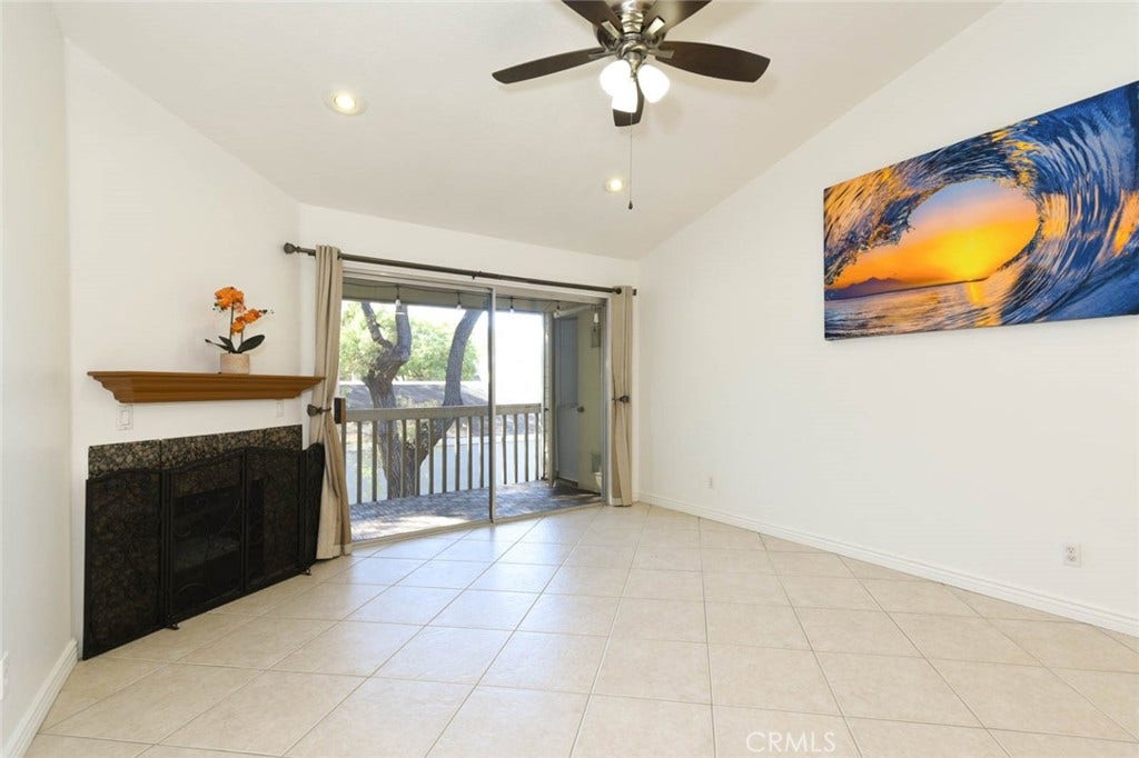 23472 Cambridge Road, #297, Yorba Linda, CA 92887 The sliding doors leads to the private balcony with the washer and dryer in the closet on the right side of the balcony. A beautiul fireplace is on the left side of the room.