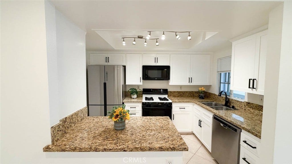 23472 Cambridge Road, #297, Yorba Linda, CA 92887 The kitchen was fully remodeled some years ago with granite countertop, gas stove, built-in microwave, stainless steel dishwasher and 4-door refrigerator.