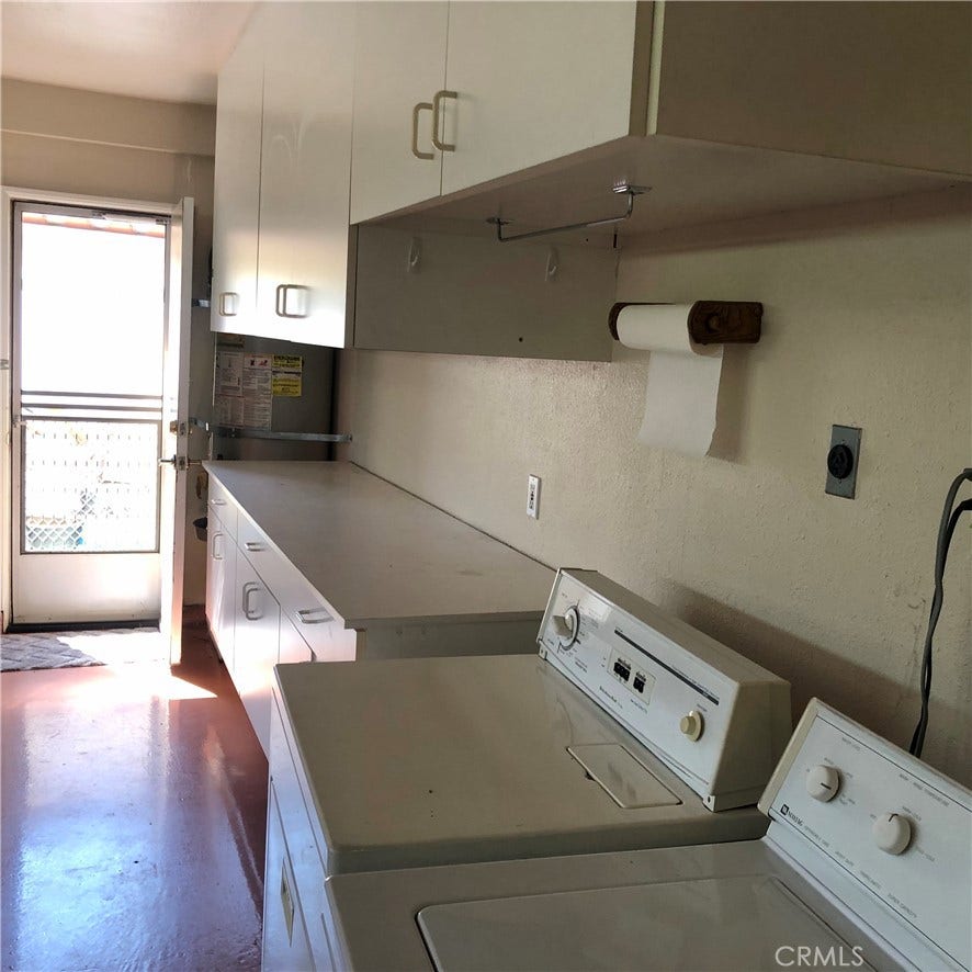 Direct access to the garage from the kitchen; notice the width of the garage that houses the washer/dryer and additional custom cabinetry and a convenient exit to the exterior.