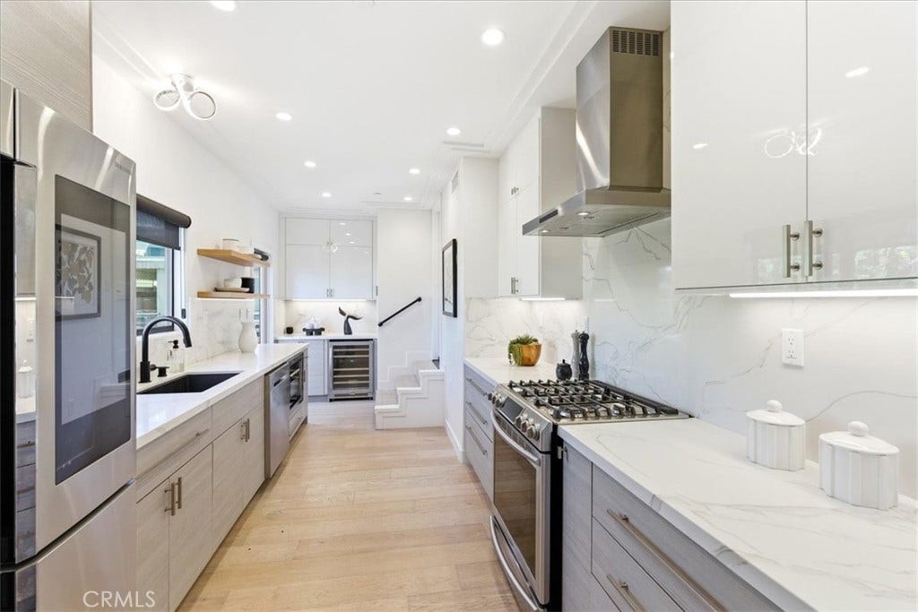 Kitchen with stainless appliances and a long counter.