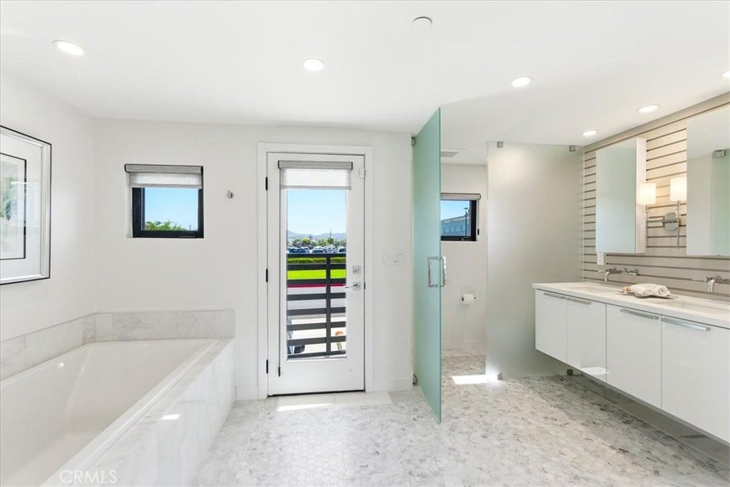 Primary bath with a soaking tub and balcony access.