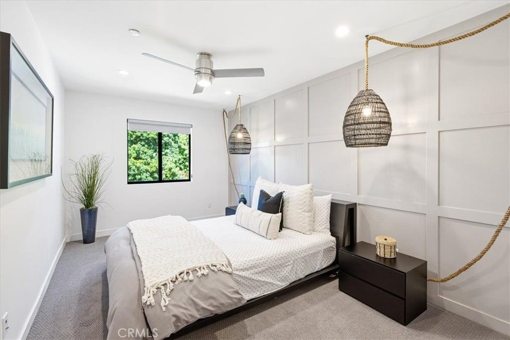 Bedroom with a ceiling fan and pendant lighting.