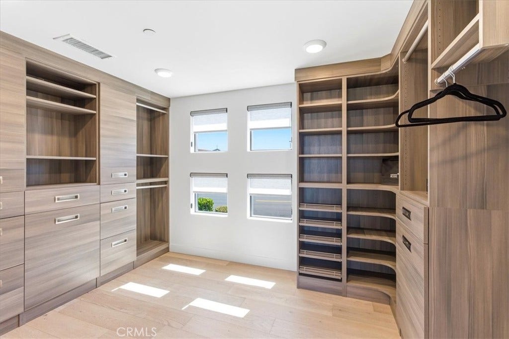 Walk-in closet with custom built-in shelving.