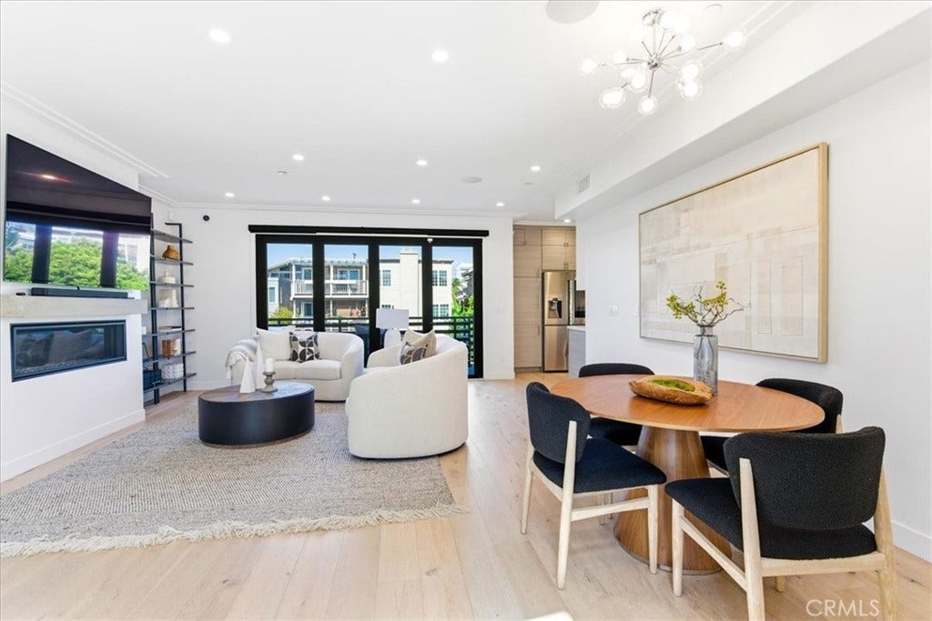 Living and dining area with a fireplace and large windows.