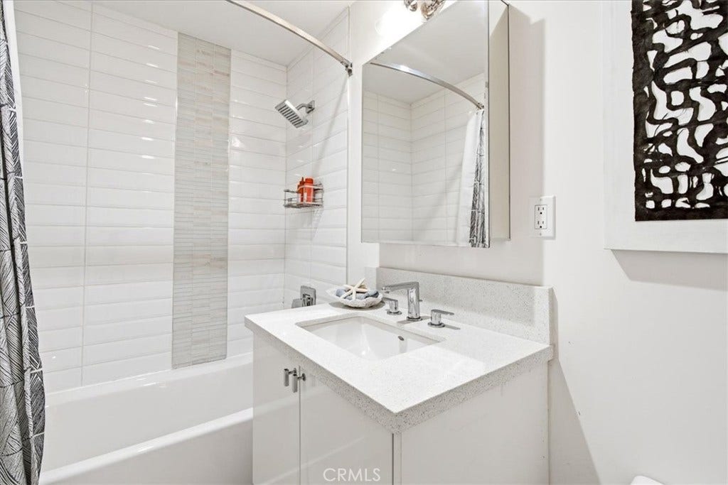 Bathroom with a tub and shower and a white vanity.