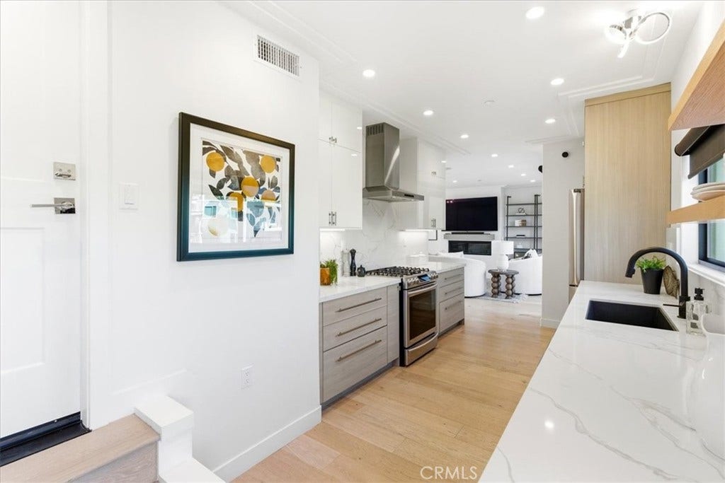 Kitchen with a range, hood, and wall oven.