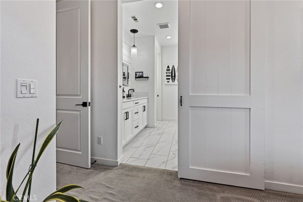 14 Marisol, Rancho Mission Viejo, CA 92694 Barn door entrance into the Primary Bathroom from the Primary Bedroom. Notice the quality of the bedroom door and the door fixtures.
