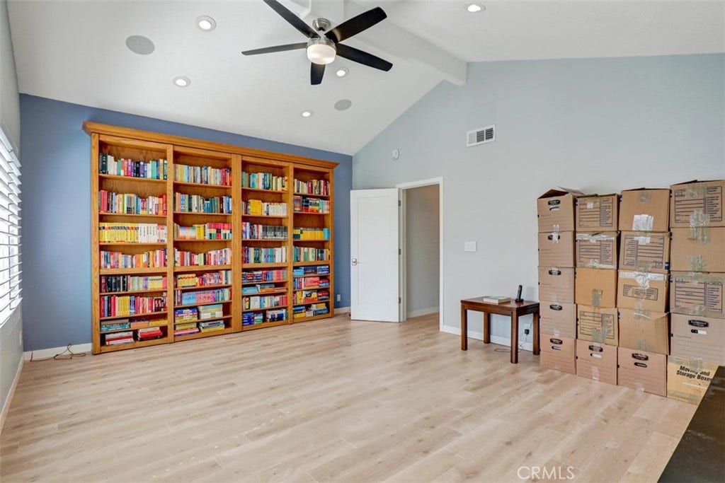 5021 Apollo Circle, Los Alamitos, CA 90720 Family room bookcase opens and there is a closet the full length of the bookcase behind.