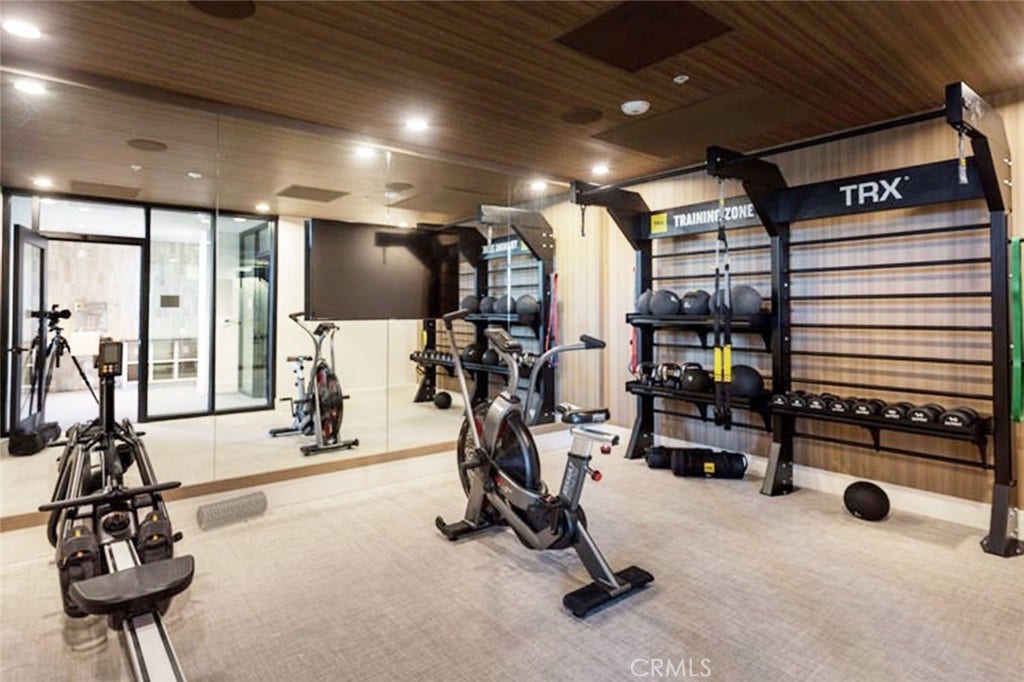 Resident fitness center with TRX functional-training wall, spin bikes and full cardio.