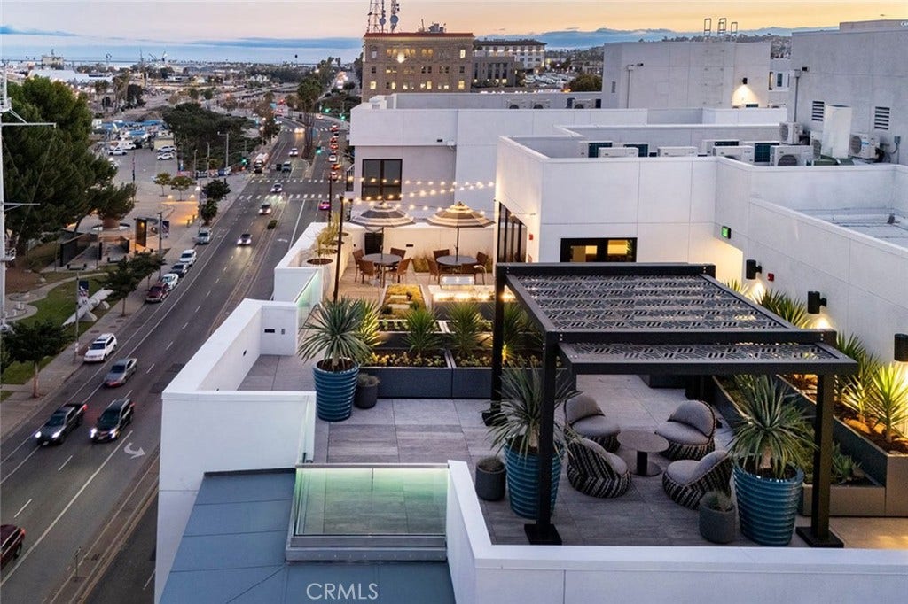 Rooftop sky deck with panoramic city & harbor views, fire-side lounges and shaded dining.