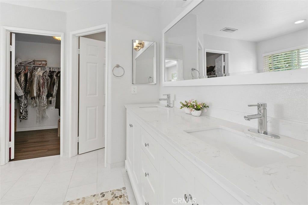 Your gorgeous upgraded primary bath features stonework in soothing neutral tones, a privacy "water closet" and spacious walk-in closet.