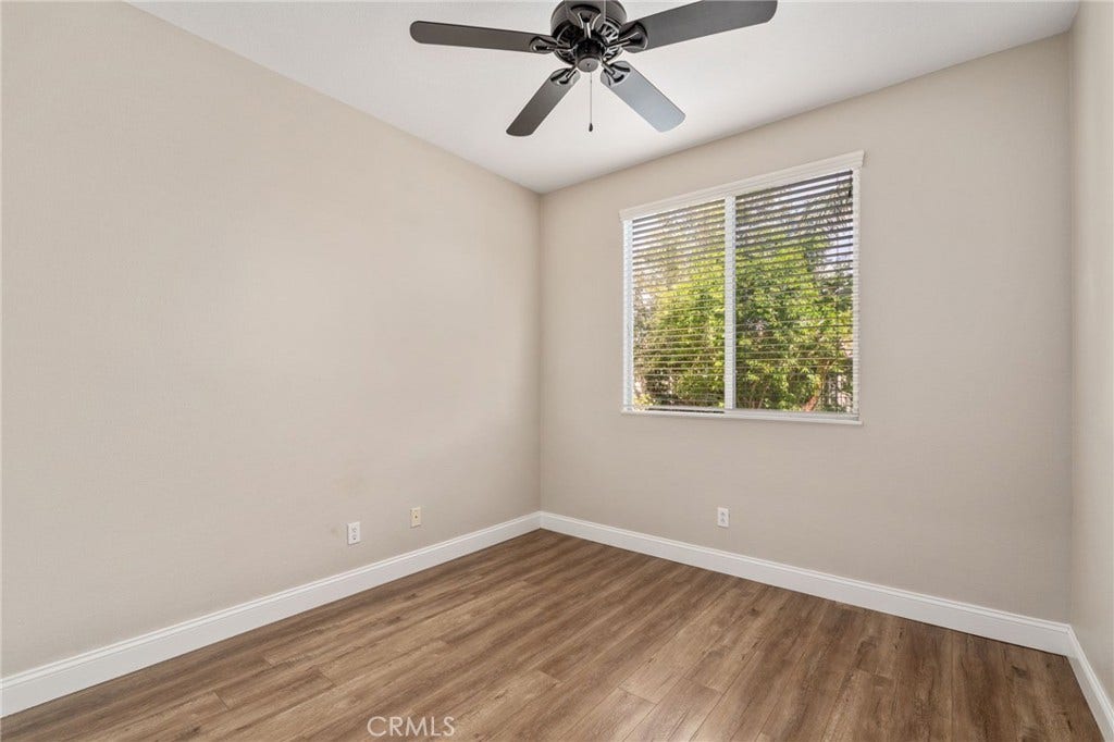 32440 Magenta Court, Temecula, CA 92592 Inviting Bedroom Featuring Wood-Look Flooring, A Ceiling Fan, Large Window Overlooking The Outdoors, And A Comfortable, Relaxing Atmosphere.
