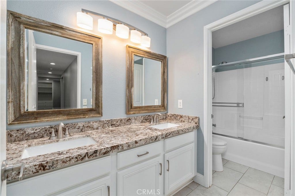 32440 Magenta Court, Temecula, CA 92592 Spacious Secondary Bathroom Featuring Dual Sinks, Attractive Granite Countertops, Framed Mirrors, White Cabinetry, And A Tub And Shower Combination.